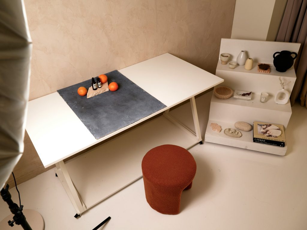 A white table with oranges sitting on top of it