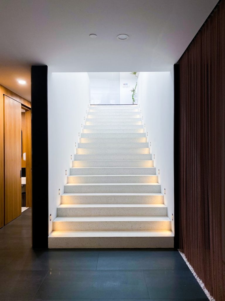 white staircase with brown wooden door