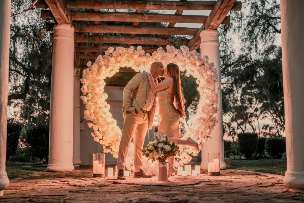 a man and a woman standing in front of a wedding arch
