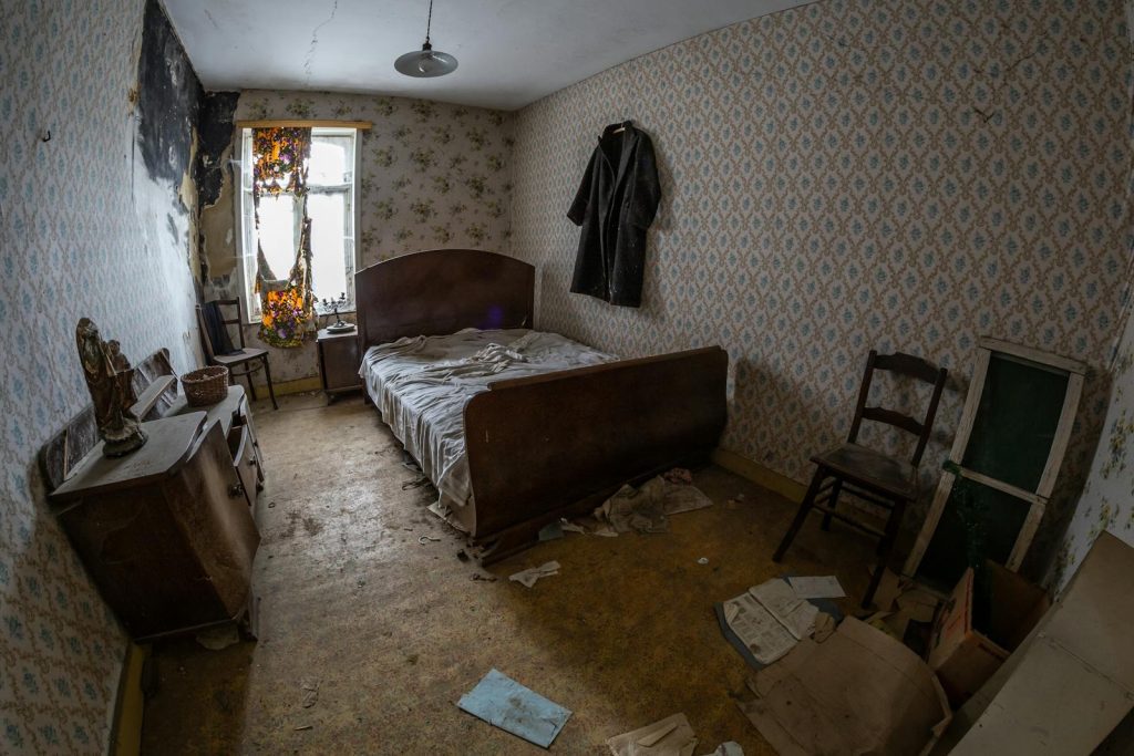 Explore an abandoned bedroom with vintage furniture in Belgium featuring a dilapidated interior.