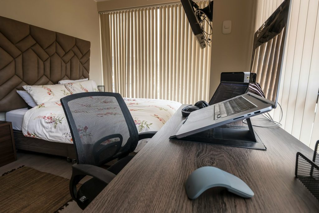 a laptop computer sitting on top of a wooden desk