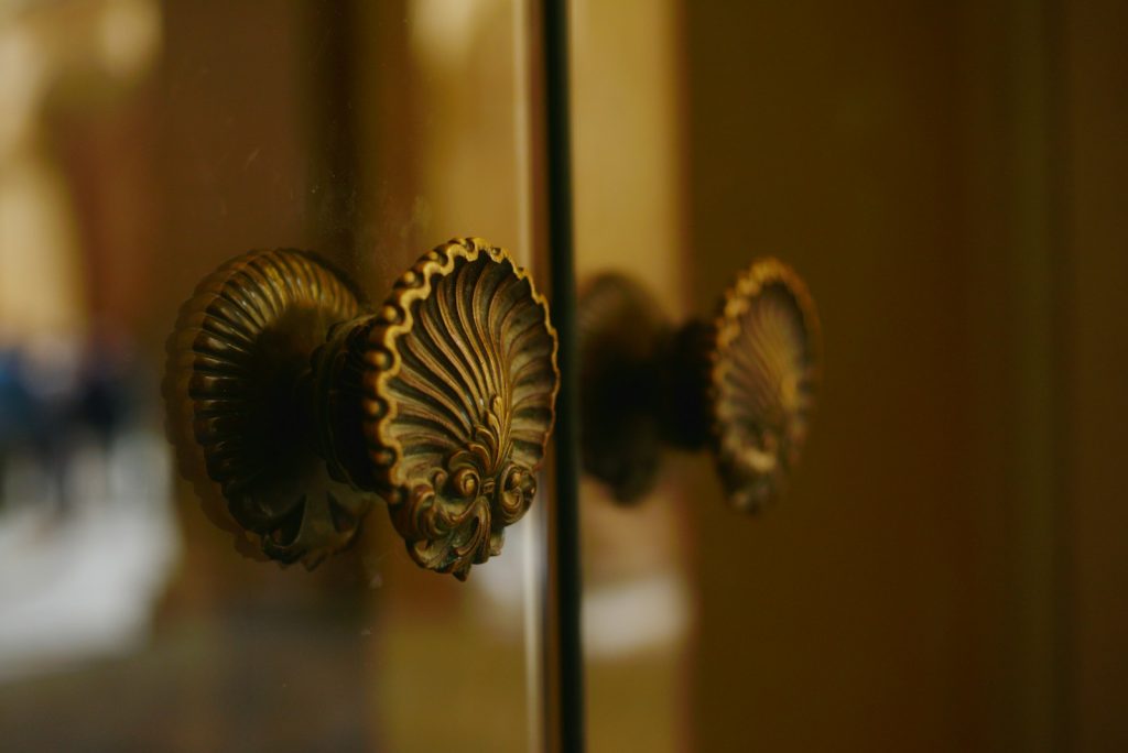 Close-up of ornate brass door handles on glass